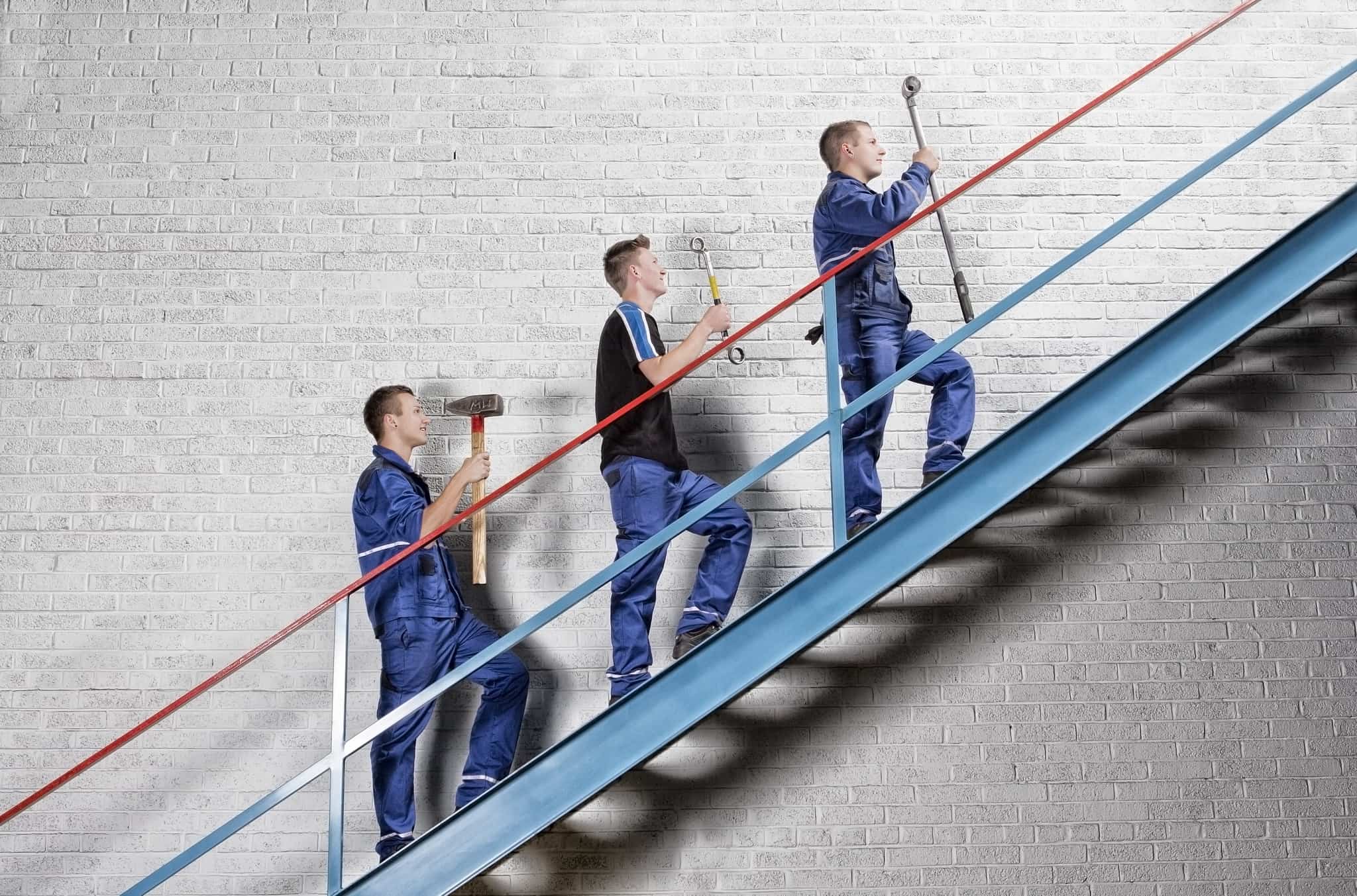 Drei männliche Lehrlinge, die die Stiege hinaufsteigen